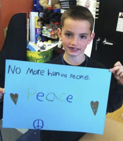 Boston Marathon bombing victim Martin Richard, 8, held a call for peace at a school event last year. He ended up dying a victim of violence. 